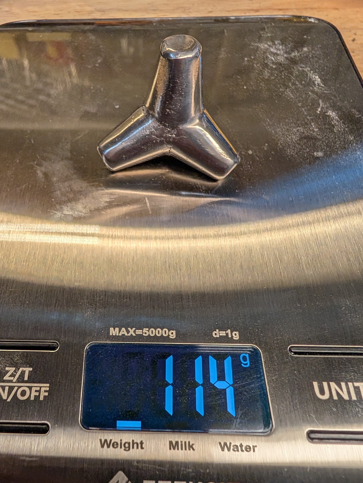 The silver tetrapod on a scale, showing 114g