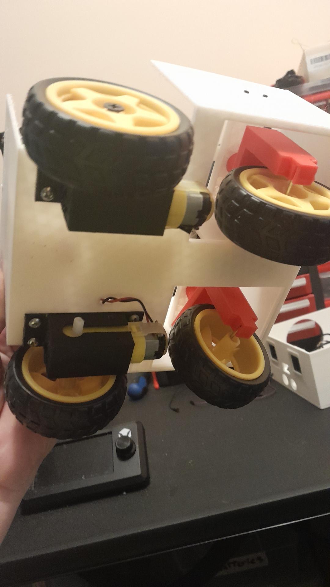 Bottom of white box showing wheels and motors