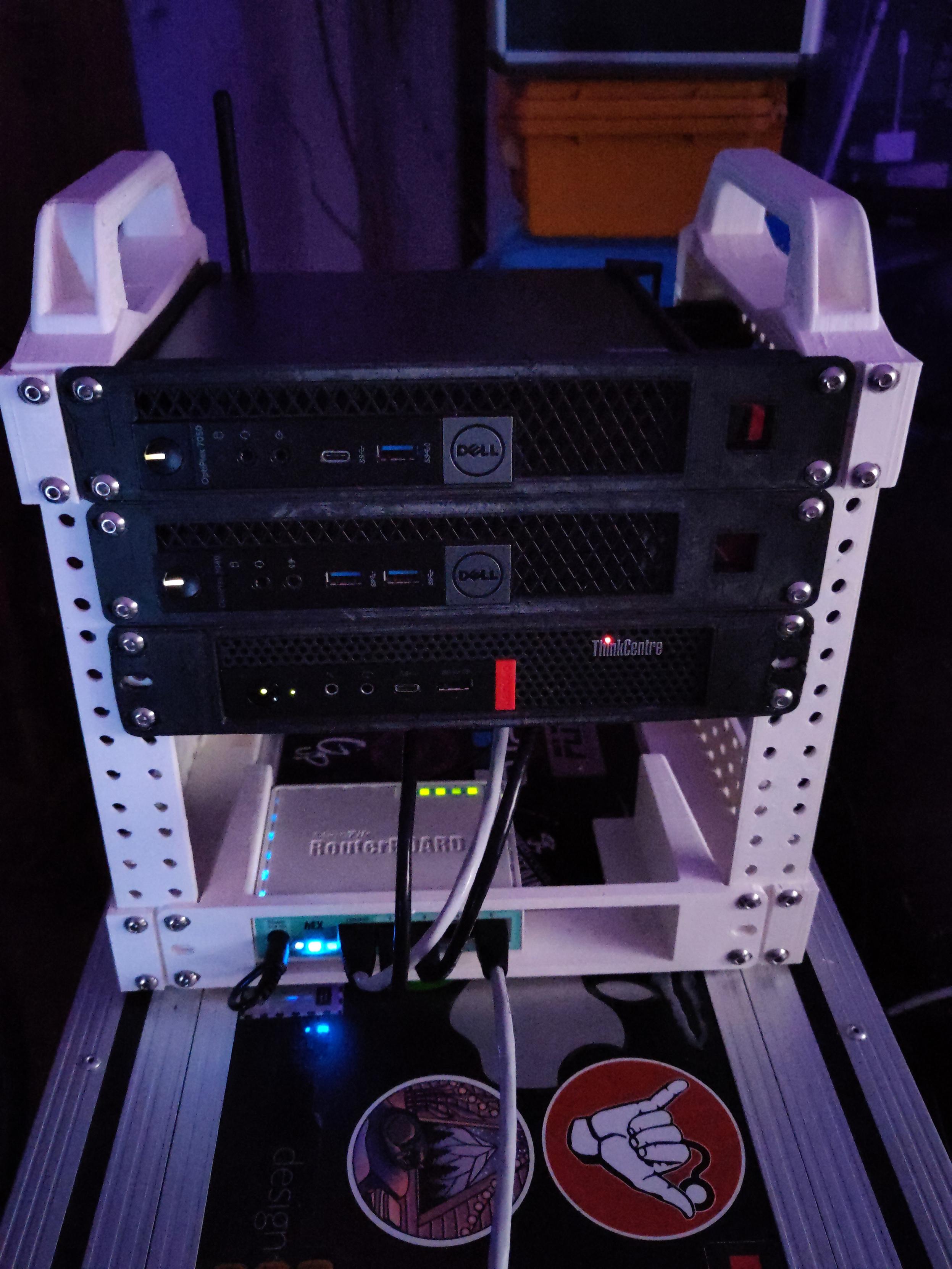 Three 1 litre PCs (Dell, Lenovo) in a 3D-printed 10 inch rack. On the bottom a small Mikrotik router.