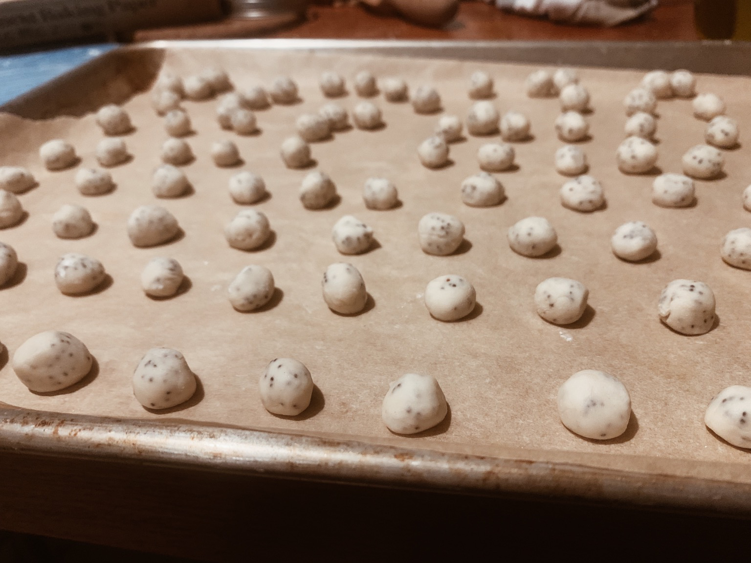 A baking sheet full of chickpea-sized poppy cookies