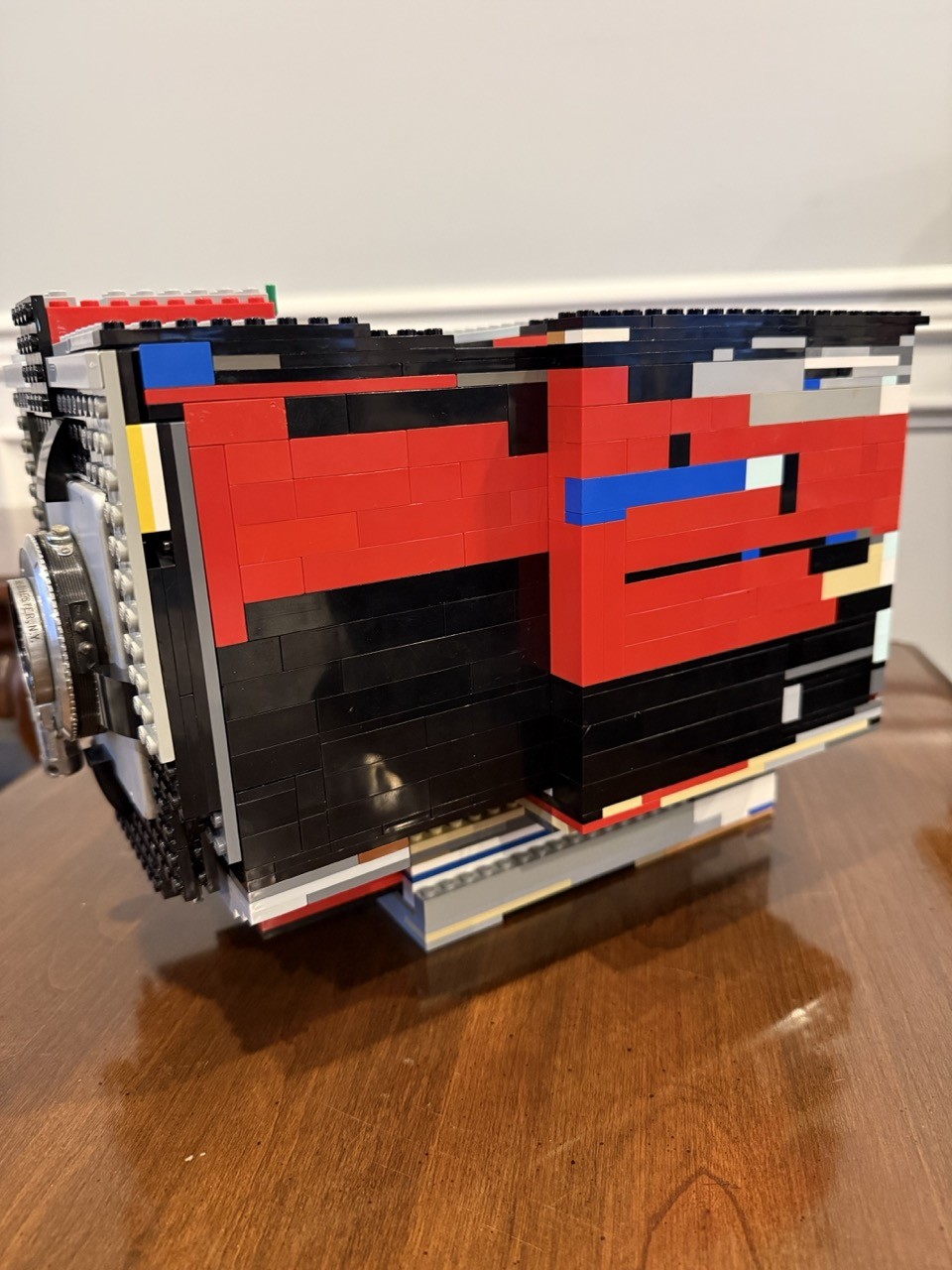 A mostly-side-view of a 4x5 film camera made of LEGO with the front portion extended (used for focusing).