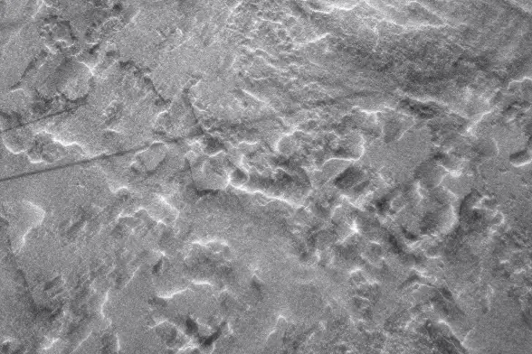 black and white double exposure photo showing a complex snow texture with a black shadow line cutting across it. Brightness and contrast were increased in post.