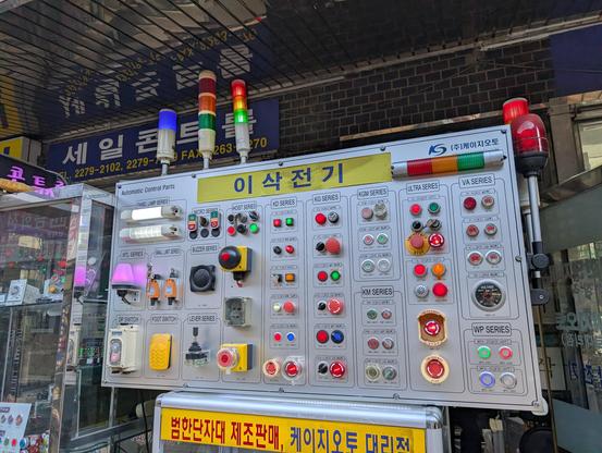 A display outside of a shop, showing all kinds of industrial indicator lights or light stacks for machines.