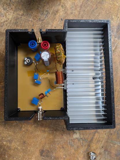 A pcb with various caps and coils, a big aluminum heat sink with two Power Mosfets attached from below. The Class E mode should stay below about 10 W dissipated energy per device.