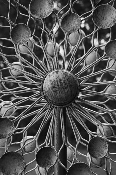A garden wind spinner is seen close up in this high contrast black and white image.