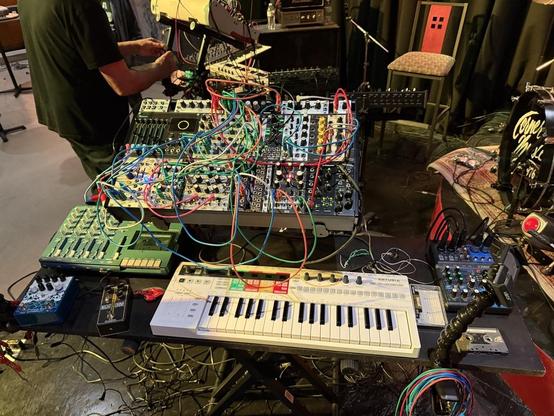 A photo of some electronic instruments, primarily eurorack, as configured for a live performance. 