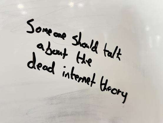 Handwritten text on a whiteboard reads: "Someone should talk about the dead internet theory."