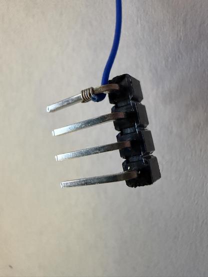 A blue wire, wrapped tightly around a metal post, as you'd expect to find on a prototype board.